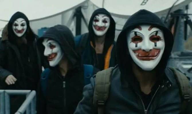 Group of people in dark hoodies wearing sinister clown masks, representing a social engineering attack scenario.