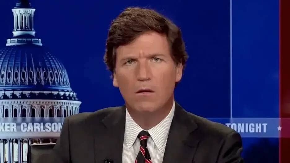 Tucker Carlson looking confused on live TV with the Capitol dome in the background